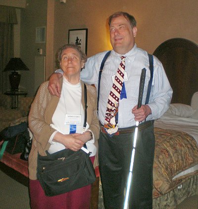 Picture of Mike and Barb standing at the foot of their bed after just getting checked into the hotel room for the National Federation of the Blind in 2008 which was in Dallas, Texas.